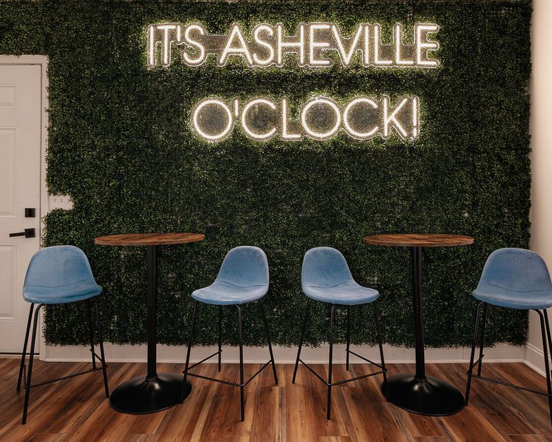 Lounge area with neon sign at an Anchor-managed Asheville property